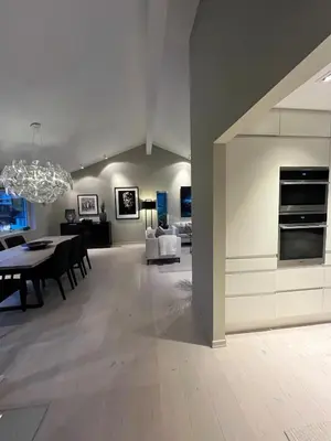 a dining room and living room with a dining table at Modern detached house by the mountains & sea in Eidsvåg