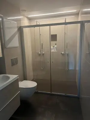 a bathroom with a shower with a toilet and a sink at Modern detached house by the mountains & sea in Eidsvåg