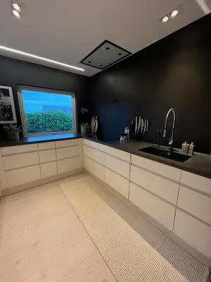 a kitchen with a large window and a sink at Modern detached house by the mountains & sea in Eidsvåg