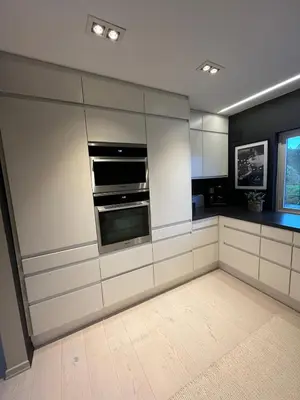 a kitchen with white cabinets and a stove at Modern detached house by the mountains & sea in Eidsvåg