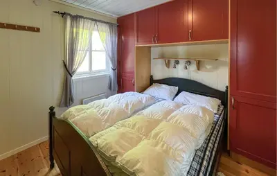 a bed with white pillows on it in a room at Gorgeous Home In Sjusjøen With Sauna in Sjusjøen