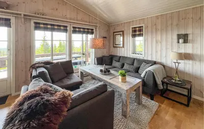 a living room with a couch and a table at Gorgeous Home In Sjusjøen With Sauna in Sjusjøen