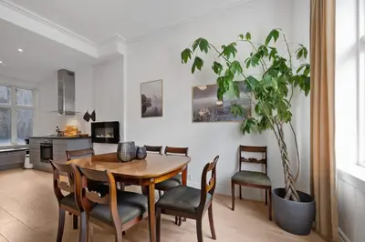 a dining room with a table and chairs and a potted plant at Unique and Spacious Home in Bergens Most Charming Area in Bergen