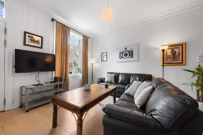 a living room with a leather couch and a table at Unique and Spacious Home in Bergens Most Charming Area in Bergen