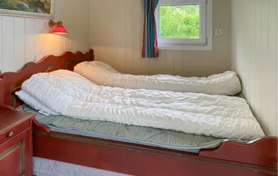 a bed with two pillows on it in a room at 1 Bedroom Amazing Home In Tingvoll in Tingvoll