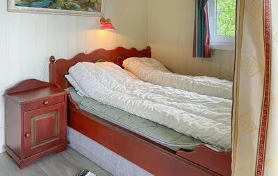 a bed in a corner of a room with a mirror at 1 Bedroom Amazing Home In Tingvoll in Tingvoll