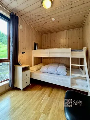 a bedroom with a bunk bed in a wooden cabin at Ski-In Out apt Hafjell - Sauna and Stunning Views in Hafjell