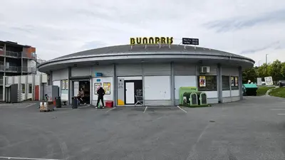 a gas station with a man standing outside of it at Cozy apartment Trondheim, free parking in the basement in Trondheim