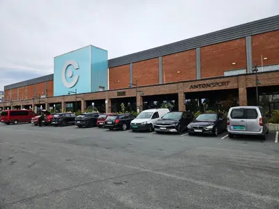 a large building with cars parked in a parking lot at Cozy apartment Trondheim, free parking in the basement in Trondheim