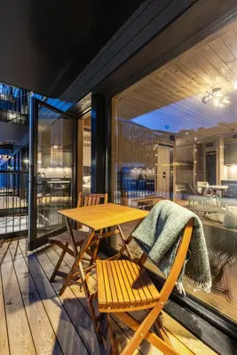 a wooden table and chairs on a balcony with a table at Fritidsbolig i Hemsedal in Kyrkjebøen