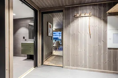 a kitchen with wooden walls and a sliding door at Fritidsbolig i Hemsedal in Kyrkjebøen
