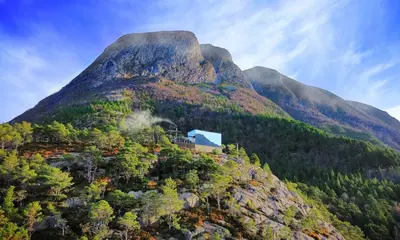 a mountain with a house on top of it at Speilhus med badestamp - en unik naturopplevelse in Solem