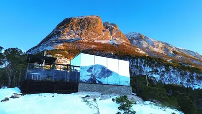 a building on top of a mountain in the snow at Speilhus med badestamp - en unik naturopplevelse in Solem
