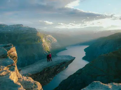 two people standing on top of a cliff overlooking a river at Hardanger Odda Apartments in Odda