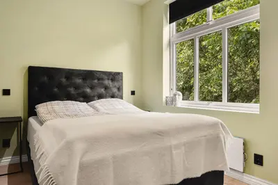 a bedroom with a bed with a large window at Hardanger Odda Apartments in Odda