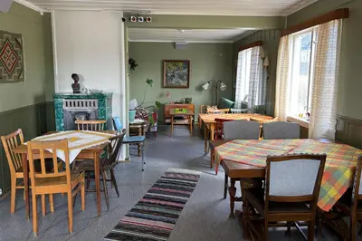 a dining room with tables and chairs and a fireplace at Voi Voi Bed & Breakfast in Røros