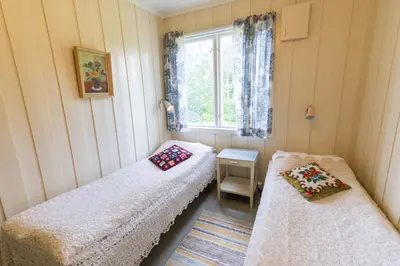 two beds in a room with a window at Voi Voi Bed & Breakfast in Røros