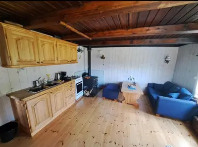 a kitchen with a blue couch and a table in a room at Beautiful place among forests and fields in a good old style in Eggedal