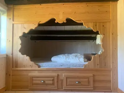 a wooden cabinet with a mattress inside of it at Beautiful place among forests and fields in a good old style in Eggedal