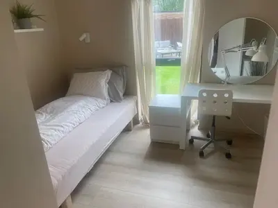 a bedroom with a bed and a desk and a mirror at Modern house - perfect for holidays in Bergen in Bergen