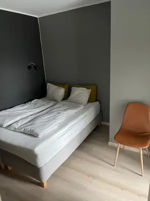 a bed and a chair in a room at Modern house - perfect for holidays in Bergen in Bergen