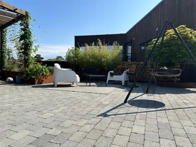 a patio with two white chairs and a swing at Modern house - perfect for holidays in Bergen in Bergen