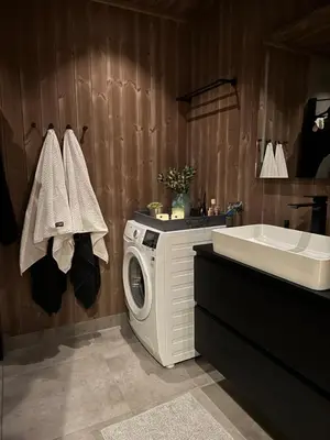a bathroom with a washing machine and a sink at Moderne leilighet ski inn og ski ut med magisk natur in Lii
