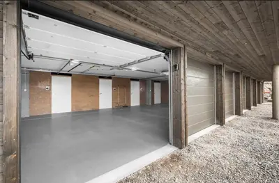 a large empty garage with a door open at Moderne leilighet ski inn og ski ut med magisk natur in Lii