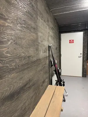 a bench in a room with a wooden wall at Moderne leilighet ski inn og ski ut med magisk natur in Lii