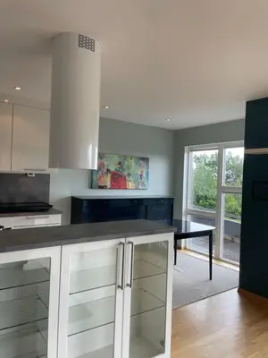 a kitchen with white cabinets and a black counter top at Panorama leilighet in Lii