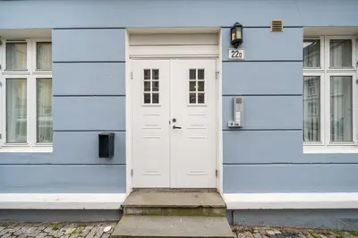 a blue house with a white door on it at Central & Modern Apartment in the Coziest Street in Bergen in Bergen