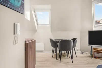 a dining room with a table and chairs and a tv at Central & Modern Apartment in the Coziest Street in Bergen in Bergen