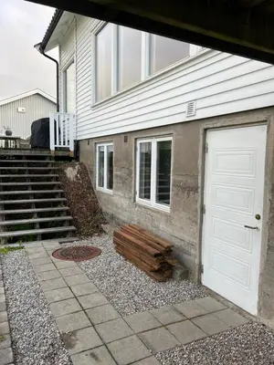 a house with a white door and a stairs at Hybel leilighet på Rosanes, Teie in Lii