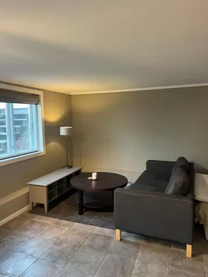 a living room with a couch and a table at Hybel leilighet på Rosanes, Teie in Lii
