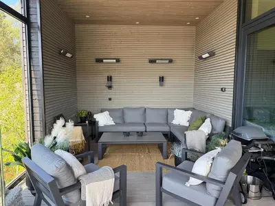 a patio with a couch and chairs and a grill at Villa Vaaganeset in Lii