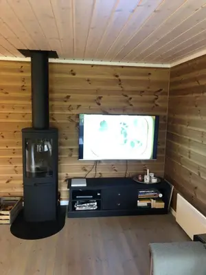 a living room with a flat screen tv and a fireplace at Familiehytte på Kvamskogen in Kvam
