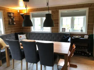 a dining room with a wooden table and chairs at Familiehytte på Kvamskogen in Kvam