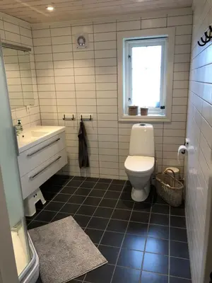 a bathroom with a toilet and a sink and a window at Familiehytte på Kvamskogen in Kvam