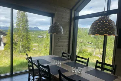 a dining room with a table and a large window at The Lookout at Beitostølen in Beitostøl