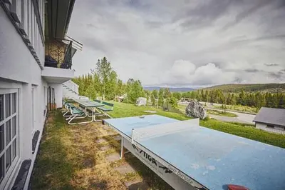 a patio with tables and chairs on the side of a building at Fisking i Valdres in Tisleidalen