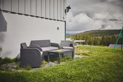 two couches and a table in a yard at Fisking i Valdres in Tisleidalen