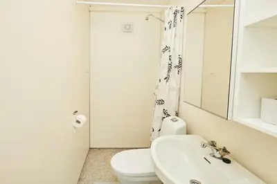a white bathroom with a toilet and a sink at Fisking i Valdres in Tisleidalen