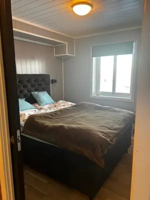 a bedroom with a large bed with a window at Flott leilighet på Voss i Tråstølsvegen med 3 soverom 6 sengeplasser in Skulestadmo