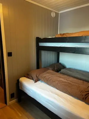 two bunk beds in a room with a white mattress at Flott leilighet på Voss i Tråstølsvegen med 3 soverom 6 sengeplasser in Skulestadmo