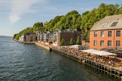 a pier with tables and chairs next to the water at Bergen pearl in historic street & easy check-in in Bergen