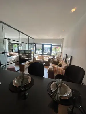 a living room with a couch and a table and chairs at Holiday apartment south Norway in Lii