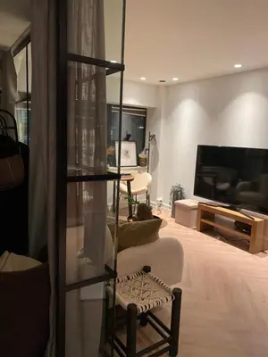 a living room with a couch and a television at Holiday apartment south Norway in Lii
