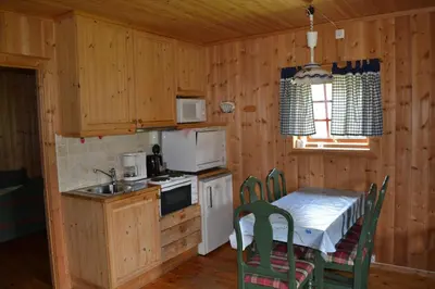 a kitchen with a table and a table and chairs at Mogard in Skjåk