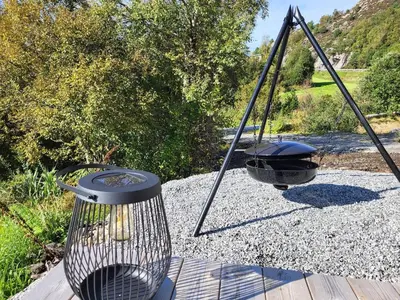 a bird feeder and a grill on a porch at Hytte ved sjøen in Røyra