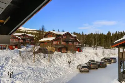 a group of cars parked in the snow near a lodge at Trysilfjell 720 by Vacation Trysil in Trysil